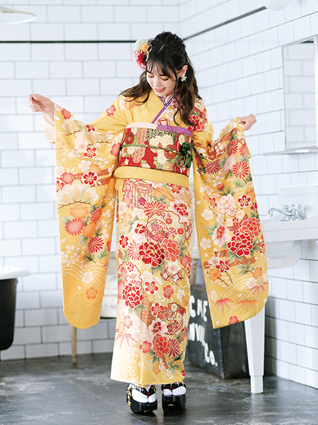 振袖コレクションNO:K106/上品で光沢のある山吹色の生地に、美しく咲く赤色の大きな牡丹の花。引き締まりのでる紫色の小物が、オトナっぽさを演出。