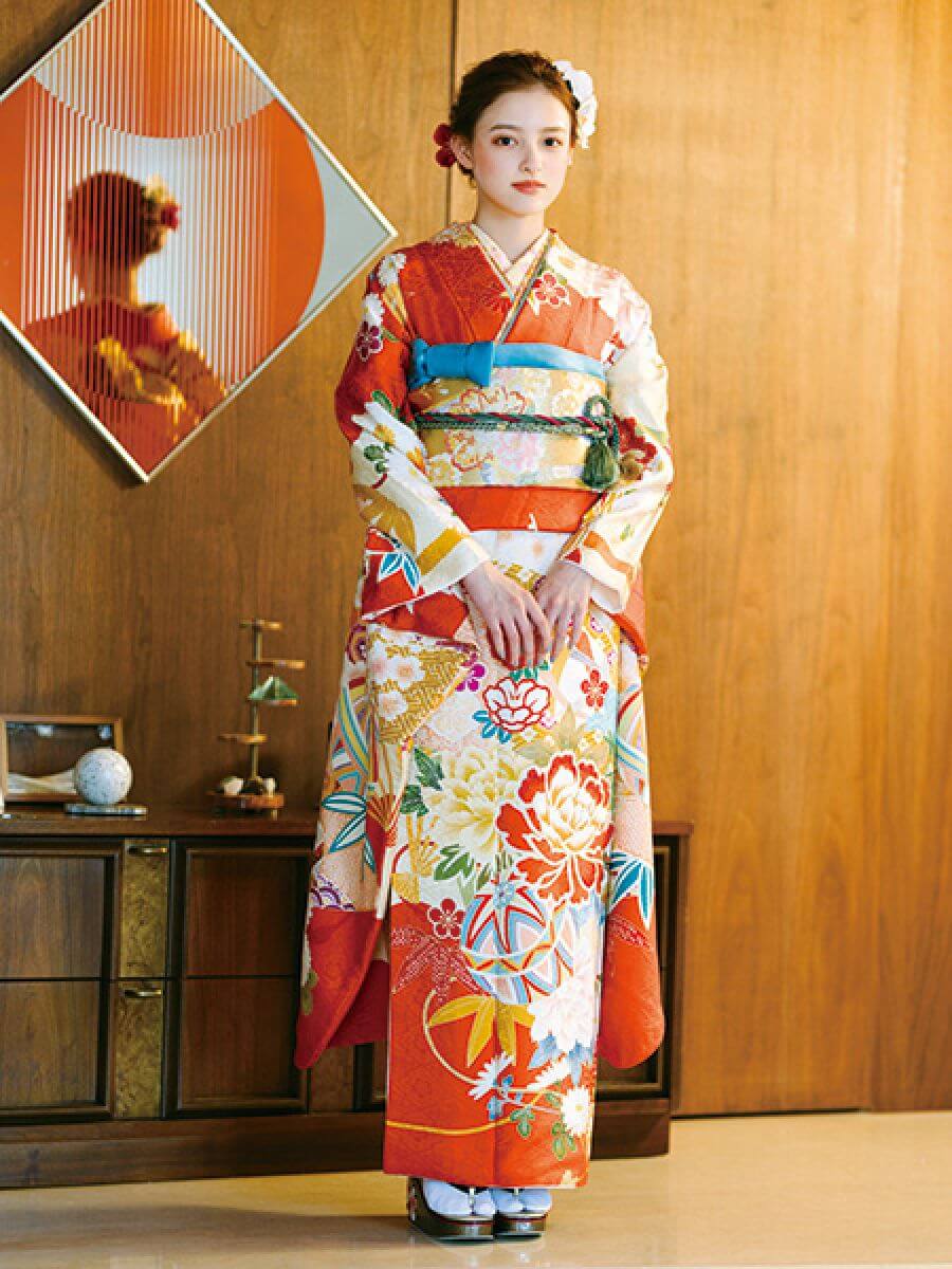振袖コレクションNO:K103/大ぶりの牡丹から大正浪漫薫る振袖。日本の伝統色である鮮やかな朱の地色とそれを際立たせる金色の帯は、まさに晴れの日にふさわしい。
